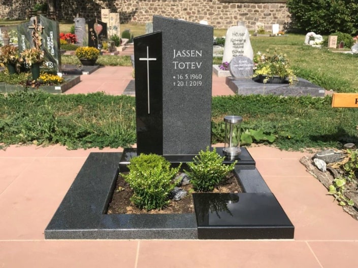 Urnengrabmal mit großem Kreuz auf dem Grabstein.